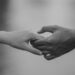 2 mensen die elkaars hand vasthouden
